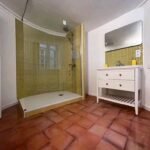 Salle de bain rénovée à Montpellier : douche carrelée, meuble vasque et murs peints en blanc